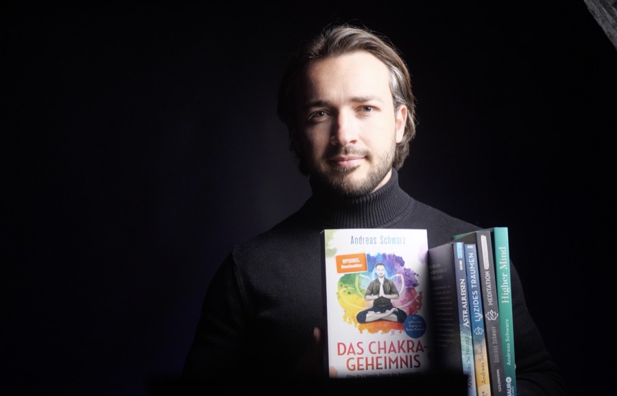 Andreas Schwarz mit seinen Büchern, darunter Das Chakra-Geheimnis